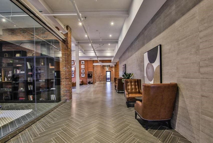 the lobby of a building with chairs and a large window