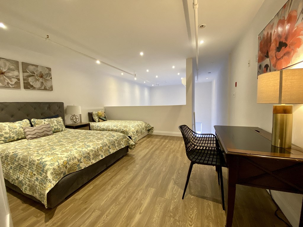 a bedroom with two beds and a desk and a chair