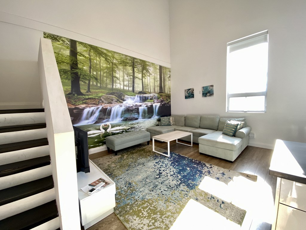 a living room with a large painting of a waterfall on the wall