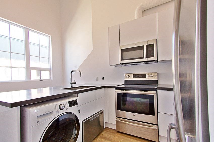 a kitchen with a washing machine and a microwave