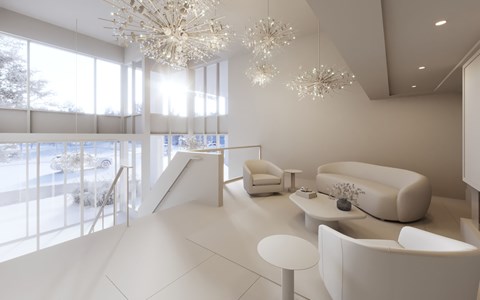 A lobby with white sofas, a coffee table, and chandeliers.