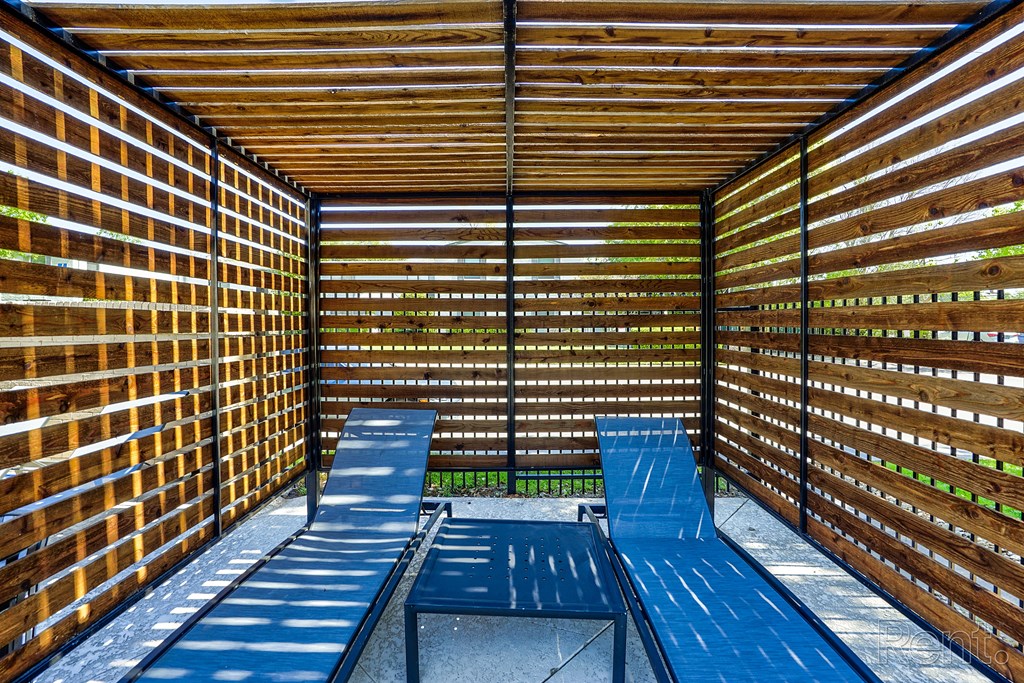 a covered patio with blue benches and tables