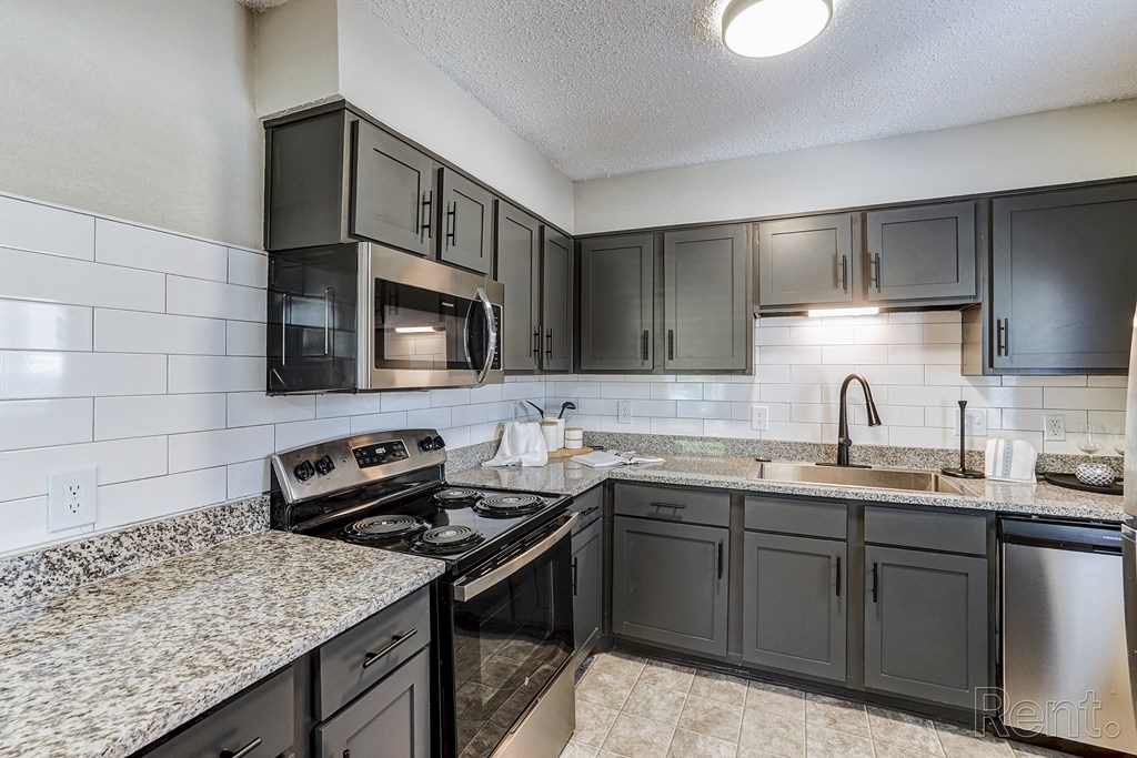 a kitchen with granite counter tops and black appliances