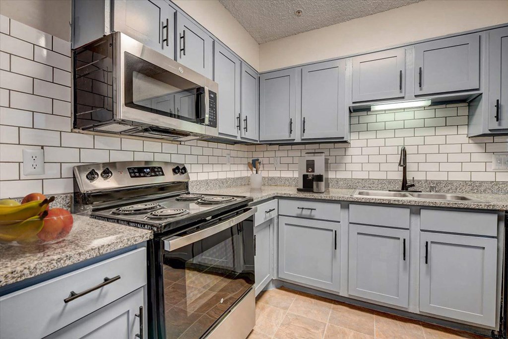 a kitchen with stainless steel appliances and white cabinets