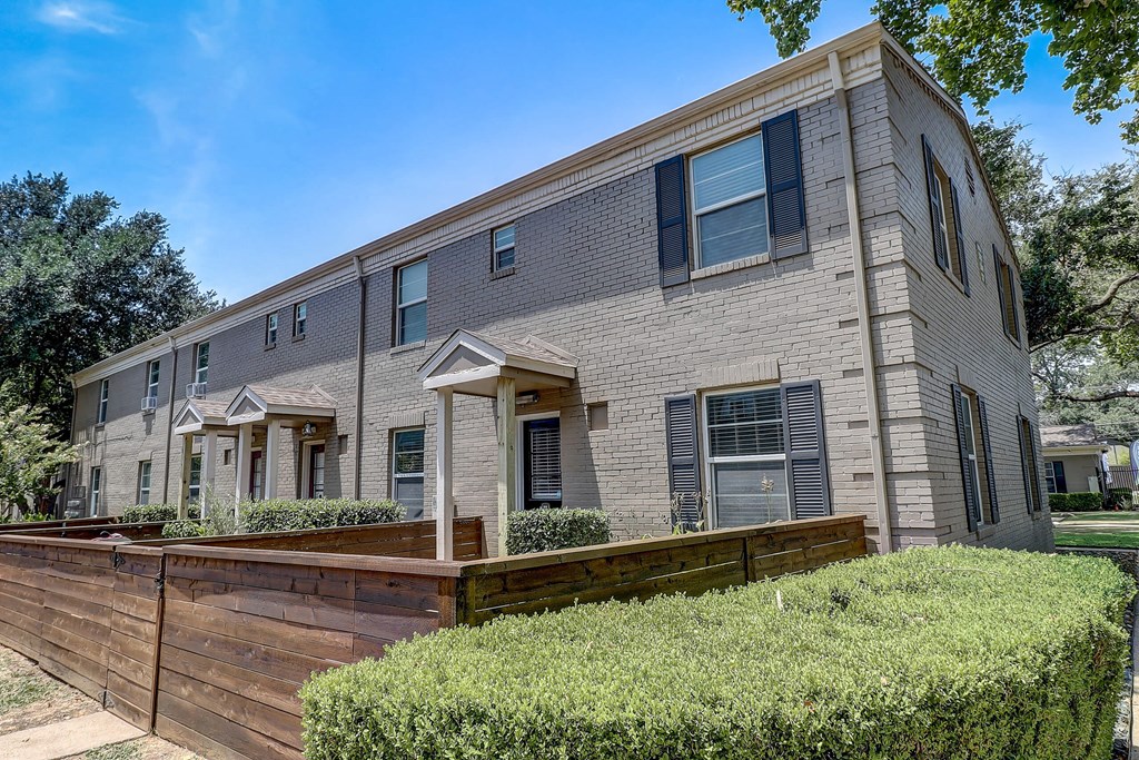 a brick building with a wooden fence in front of it