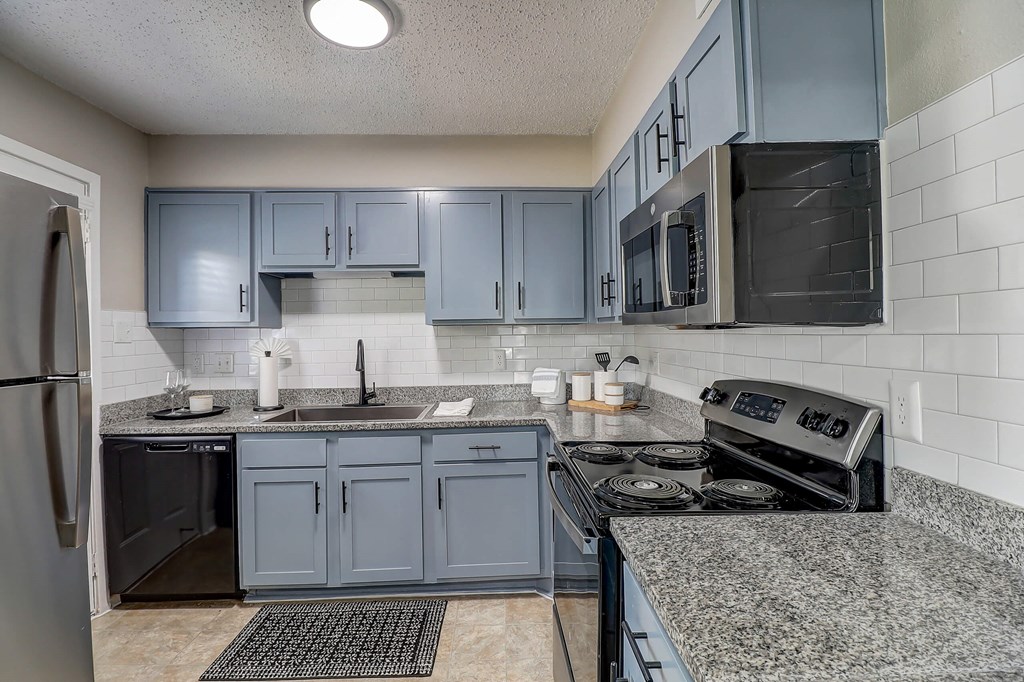 a kitchen with granite counter tops and blue cabinets