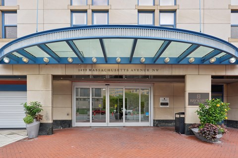 The front of a building with a glass entrance and a sign that says 1499 Massachusetts Avenue NW.
