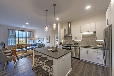 a kitchen with a kitchen island, white cabinets and stainless steel appliances