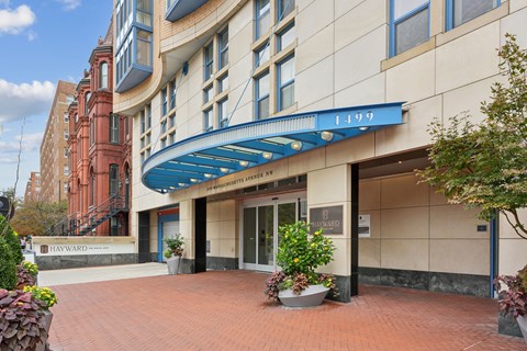 The entrance to a building with a blue awning and a sign that reads "Hayward.".