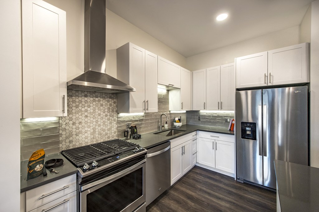 a kitchen with white cabinets and stainless steel appliances