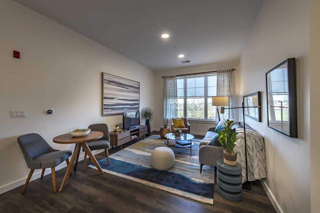 a living room with a couch table and chairs and a tv