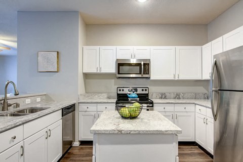 a kitchen with white cabinets and stainless steel appliances