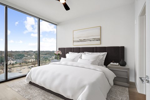a bedroom with a king sized bed and a large window