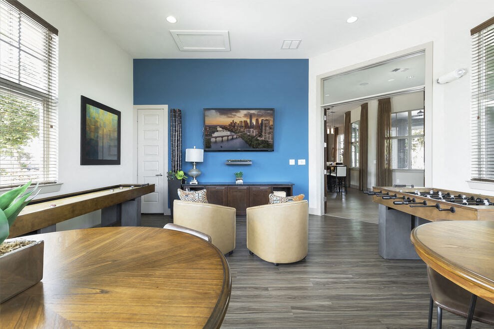 a common area with tables and chairs and a foosball table