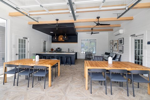 a large dining room with tables and chairs and a kitchen