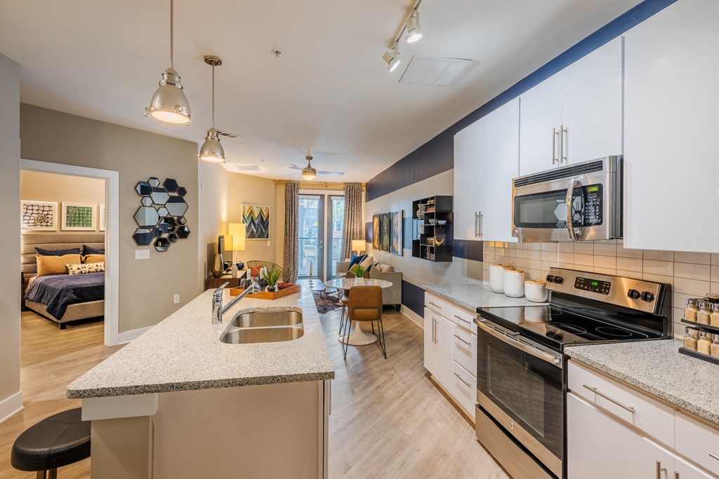 an open kitchen and living room with an island and a sink