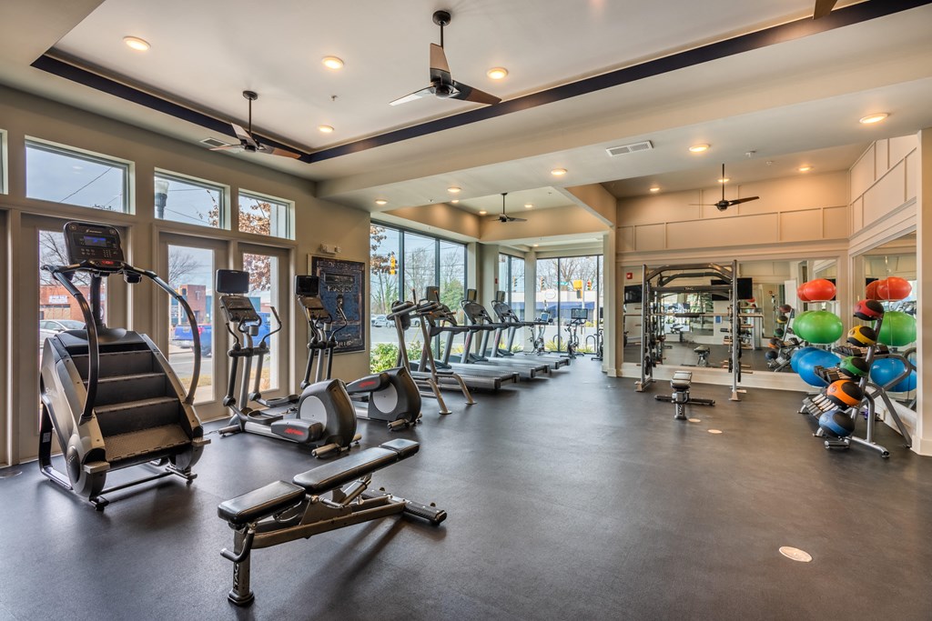 a gym with weights and other exercise equipment and windows