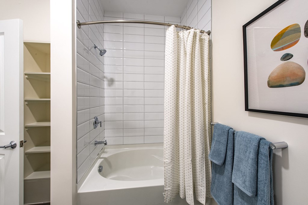 a bathroom with a white tub and a white shower curtain