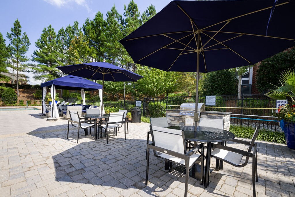 a patio with tables and umbrellas at Tradition at Stonewater, North Carolina