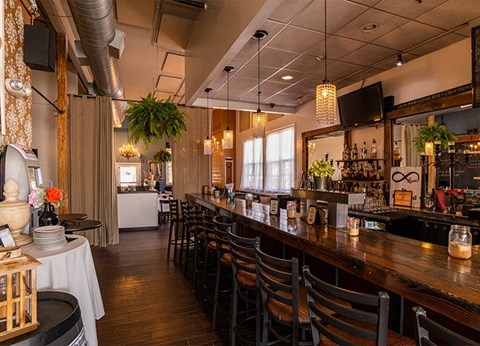 a long bar in a restaurant with tables and chairs