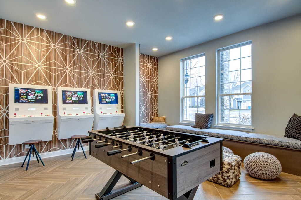 a games room with a foosball table and three arcade games