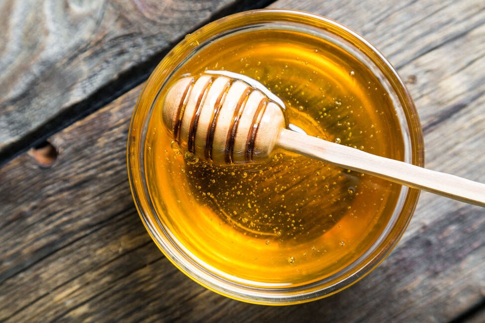 a jar of honey with a wooden spoon