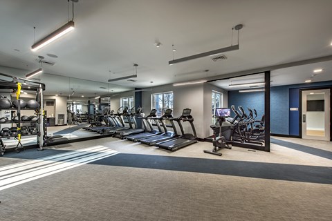 a spacious fitness center with cardio machines and weights