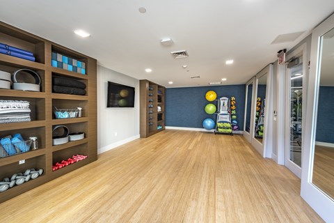 a fitness room with a wood floor and a blue accent wall