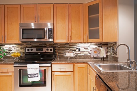 A kitchen with wooden cabinets and a black stove top oven.