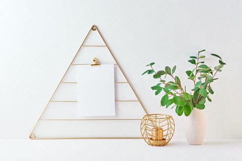 a white wall with a white vase with a green plant