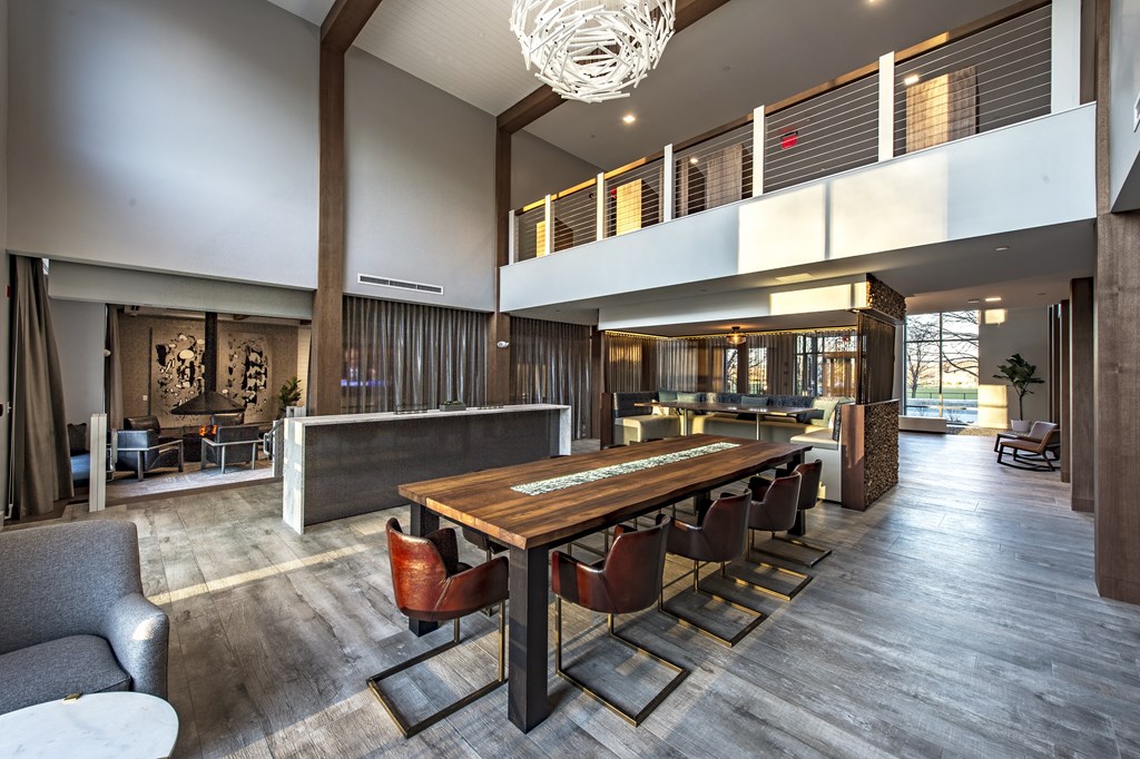 a large wooden table and chairs in a room with a high ceiling