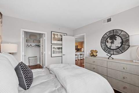 A bedroom with a large bed and a dresser with a mirror.