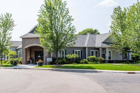 a house with a driveway and trees in front of it