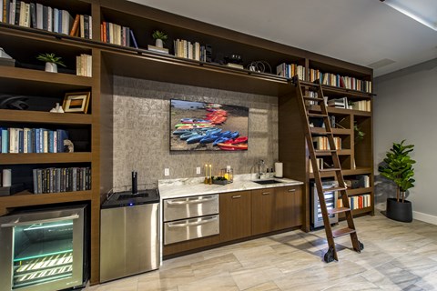 complimentary coffee station with a ladder leading up to a bookshelf