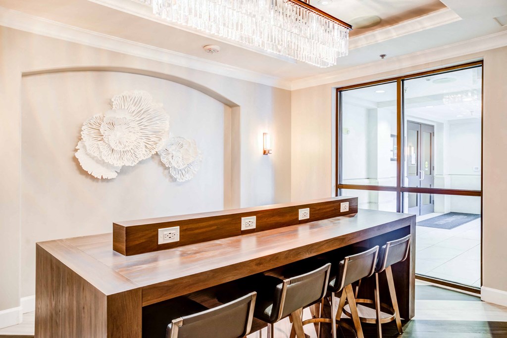 A long wooden table with chairs and a decorative wall piece.