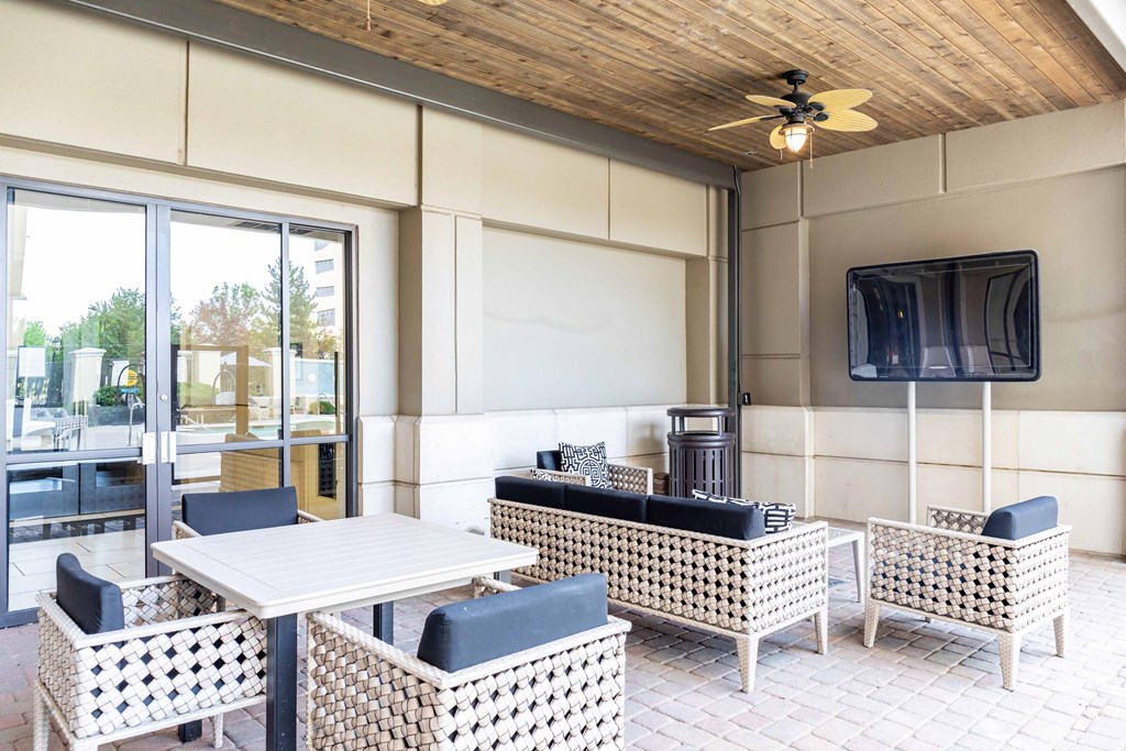 A patio with a table and chairs and a television.