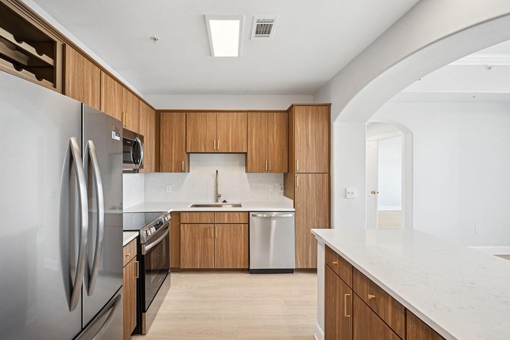 A modern kitchen with wooden cabinets and stainless steel appliances.