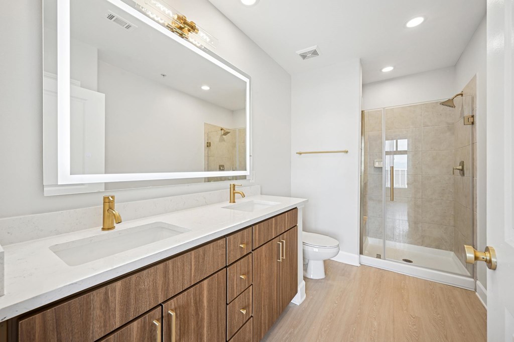 A bathroom with a white counter top and a white sink.