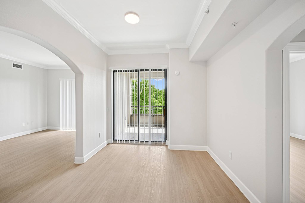 A spacious room with wooden floors and white walls.