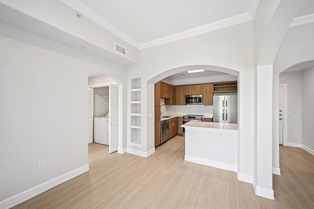 A kitchen with white cabinets and a wooden island.