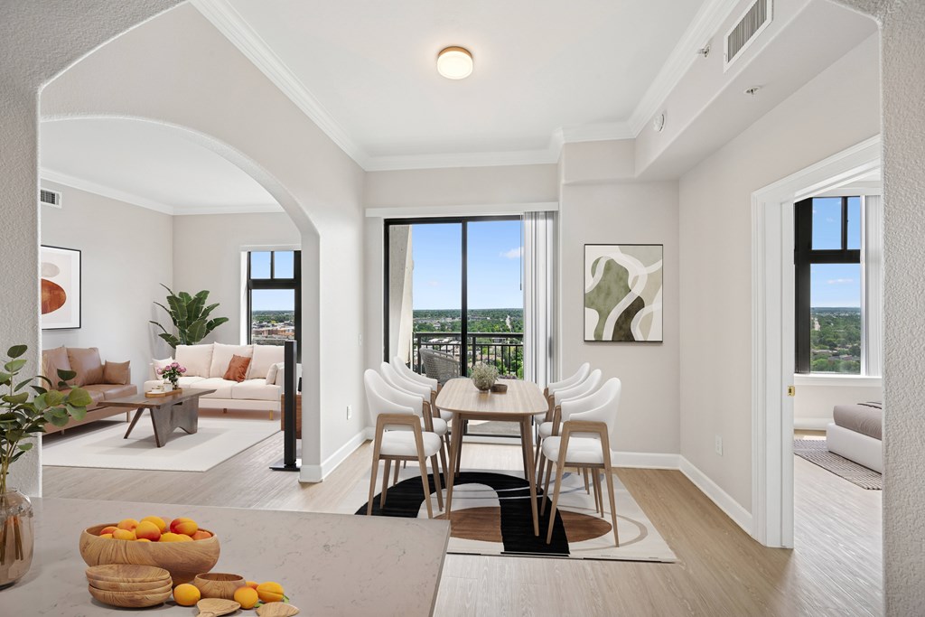 A dining room with a table and chairs and a view of the city.