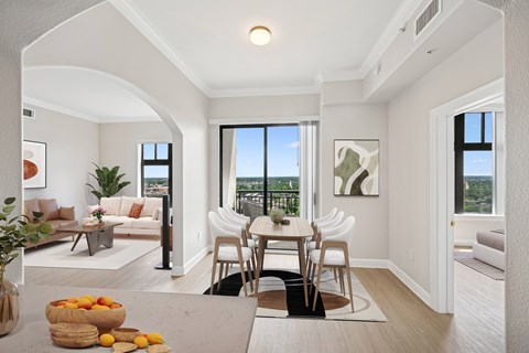 A dining room with a table and chairs and a view of the city.