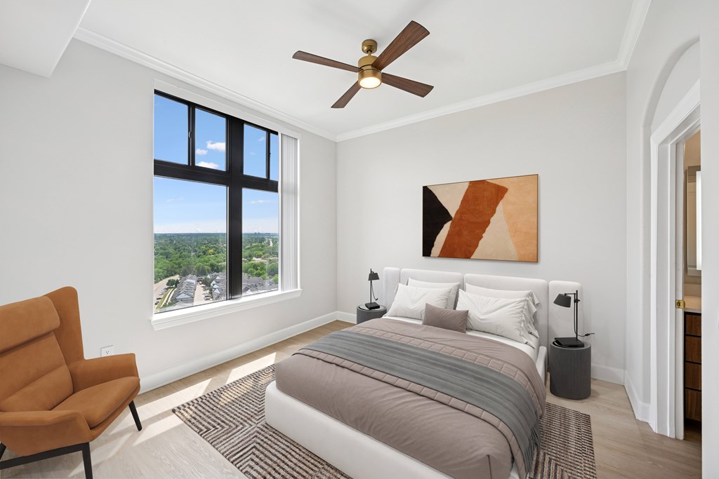 A bedroom with a large bed, a chair, and a painting on the wall.
