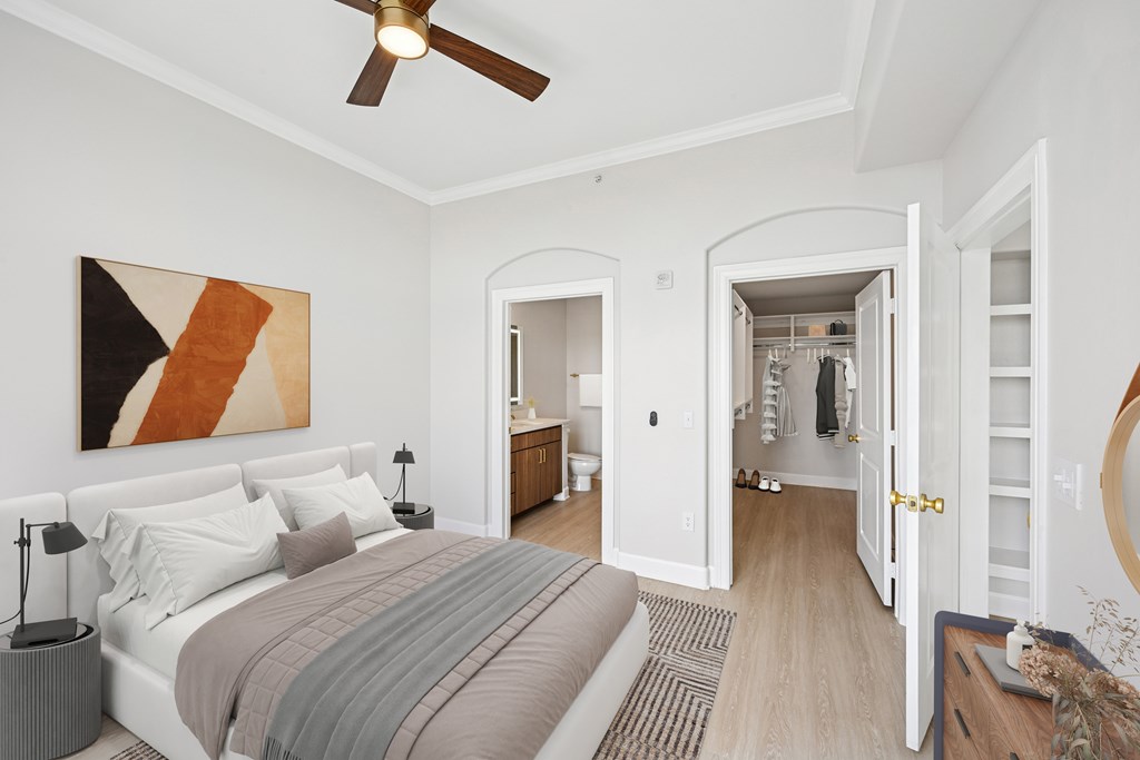 A bedroom with a large bed and a painting on the wall.