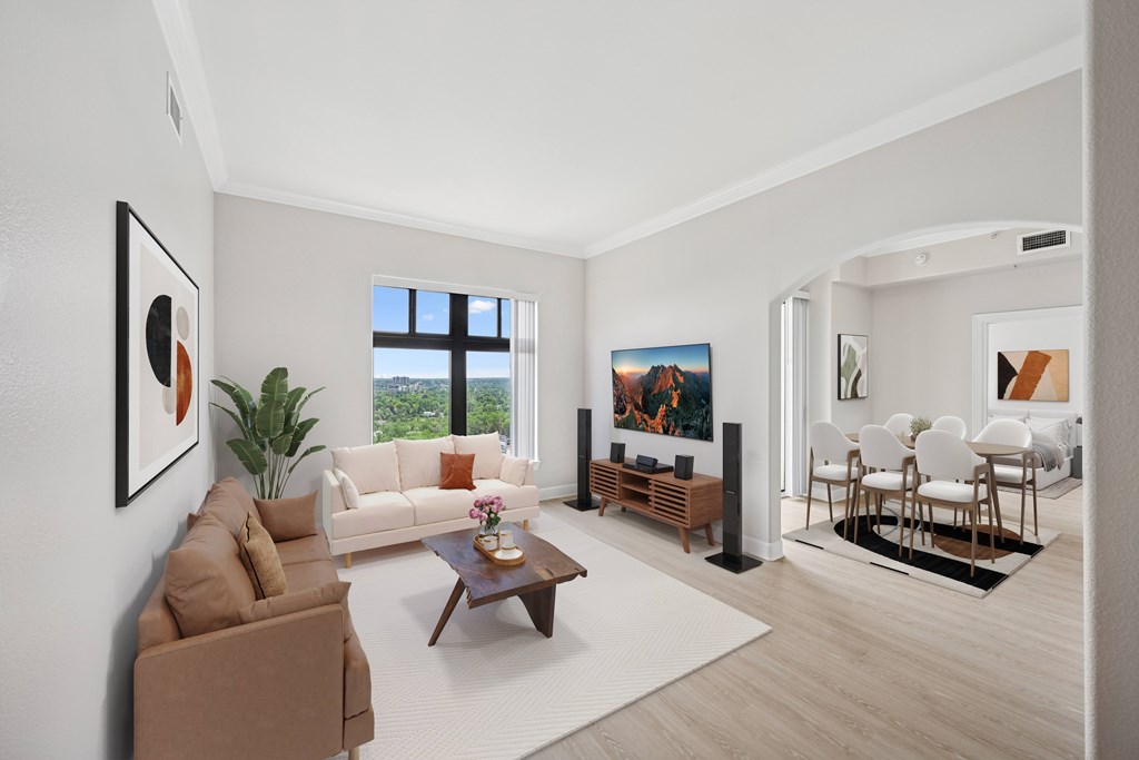 A living room with a brown couch, a coffee table, and a painting on the wall.