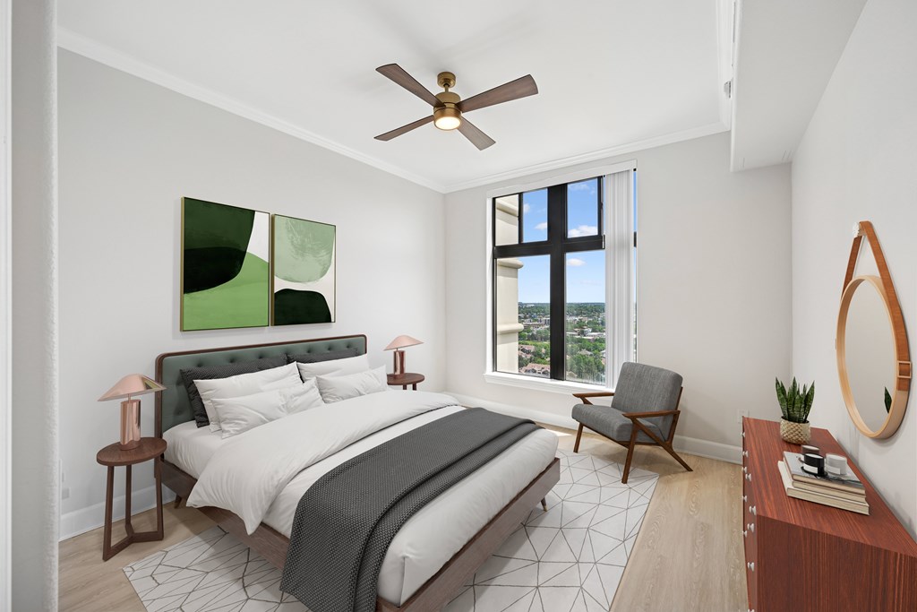 A bedroom with a large bed and a ceiling fan.