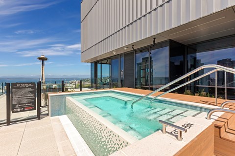 A modern pool with a glass wall and a metal railing.