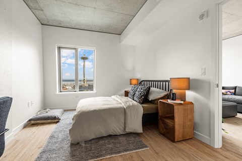 a bedroom with a bed and a couch and a window