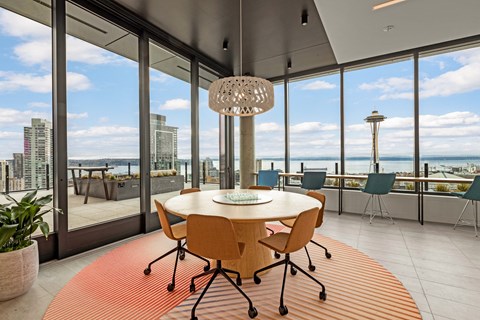 a dining room with a view of the ocean and a table and chairs
