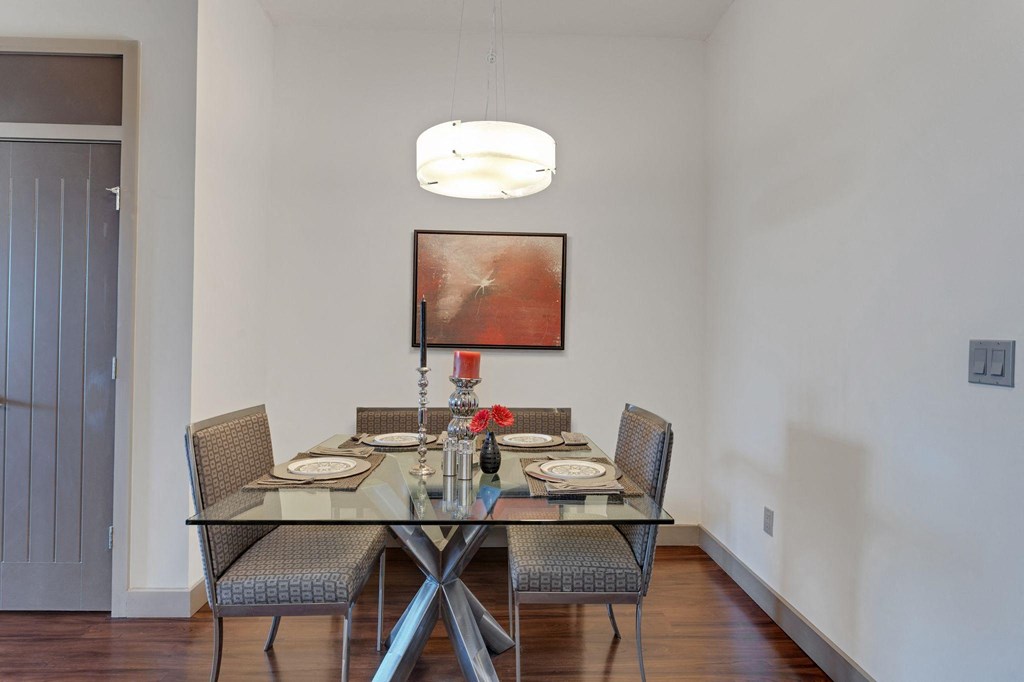 a dining room with a glass table and chairs